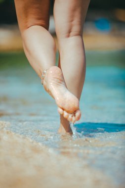 sahil yakından yürüyen kadın bacakları