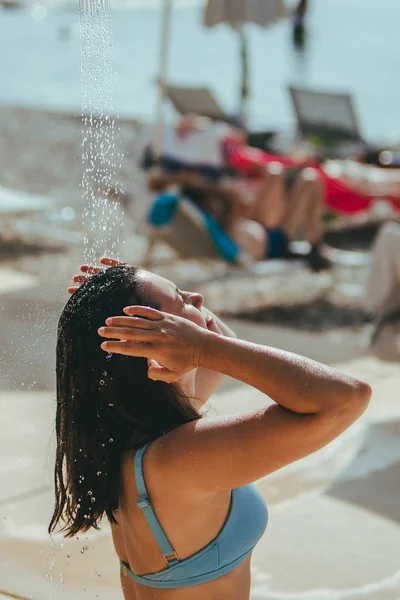 Žena, která se sprchovala na mořské pláži. vyperte slanou vodu — Stock fotografie