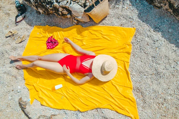 Frau ruht sich auf gelber Decke aus und sonnt sich mit Strohhut — Stockfoto