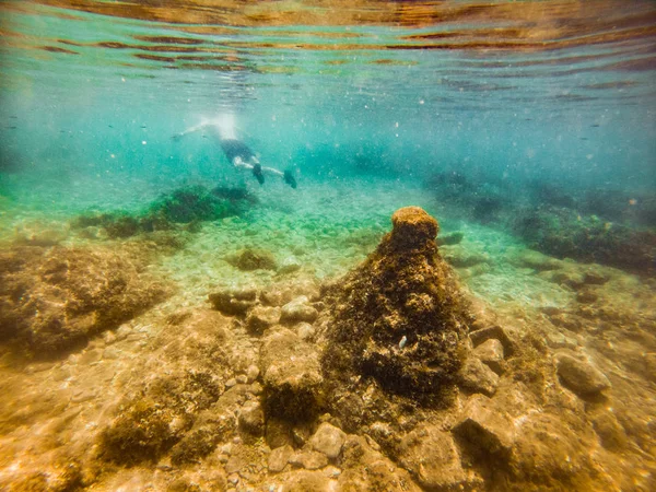Vista di roccia fondo mare uomo nuoto sott'acqua su sfondo — Foto Stock