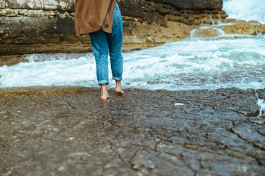 kayalık plaj yalınayak ıslak kot tarafından yürüyen kadın
