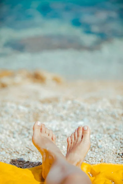 Donna gambe su coperta gialla alla spiaggia soleggiata da vicino — Foto Stock