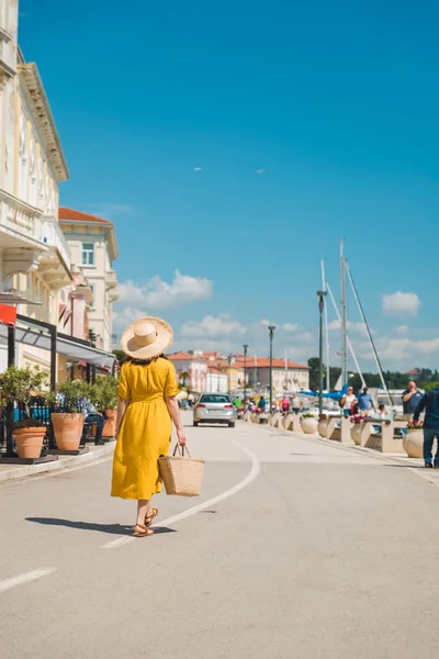 Mulher em sundress amarelo andando pela cidade de verão resort — Fotografia de Stock