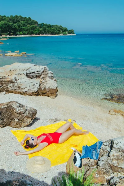 Donna prendere il sole in spiaggia in giornata di sole — Foto Stock