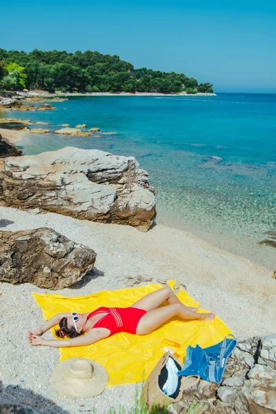 Güneşli bir günde deniz plajında güneşlenen kadın — Stok fotoğraf