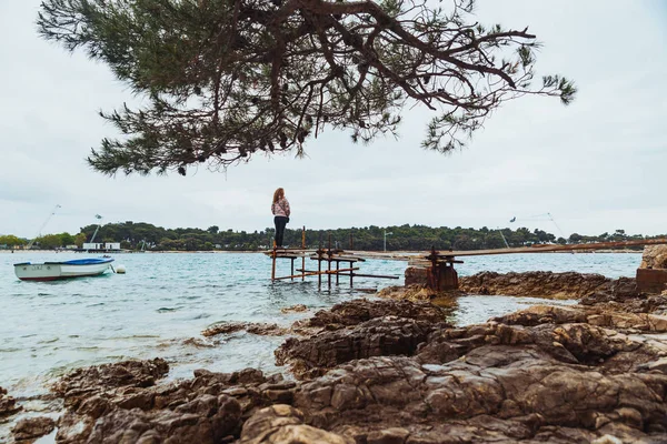 穏やかな海を見て釣り桟橋に立っている女性 — ストック写真