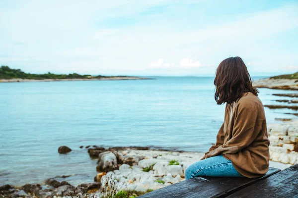 Mulher sentada no banco olhando no iate na baía — Fotografia de Stock