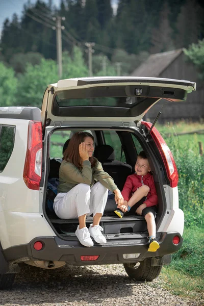 어린 어머니와 함께 아이 소년 앉아 에 앉아 자동차 트렁크 휴식 에 여름 화창한 날 — 스톡 사진