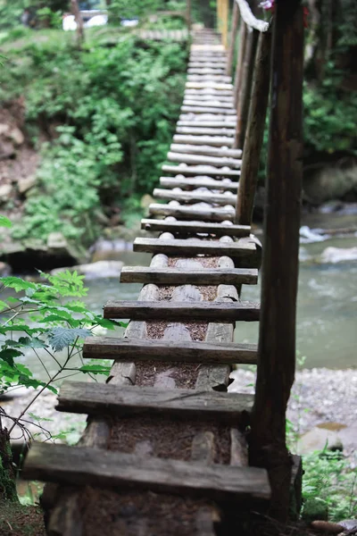 Small wooden bridge cross mountain river — Stock Photo, Image