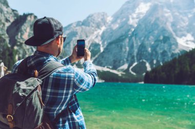 adam dağlarda göl onun telefonu fotoğraf çekmek