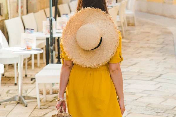 Mujer en vestido amarillo caminando por la calle de la ciudad del complejo entre mesas de restaurante cafetería — Foto de Stock