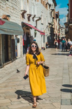 küçük hırvat şehir caddesinde yürüyen sarı sundress turist kadın