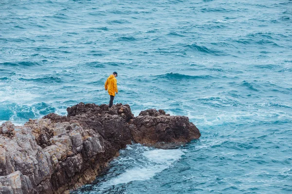 Homem andando por rocha para invadir o mar — Fotografia de Stock