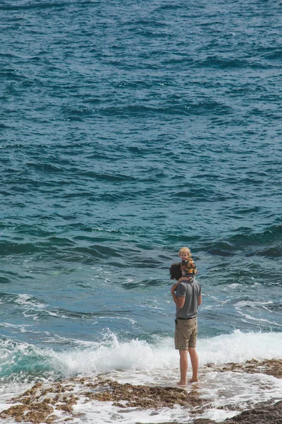 PULA, CROATIE - 20 mai 2019 : un jeune père tenant un enfant sur des épaules marchant sur une plage maritime — Photo