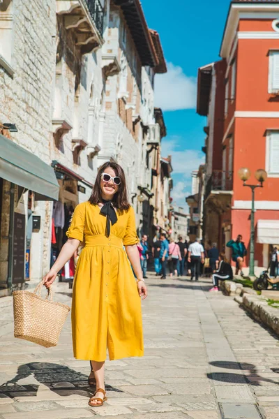 Turistická žena ve žlutém slunci chůze po malé chorvatské městské ulici — Stock fotografie