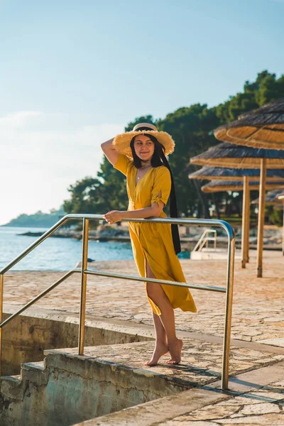 Junge hübsche Frau in gelbem Kleid am Meeresstrand — Stockfoto