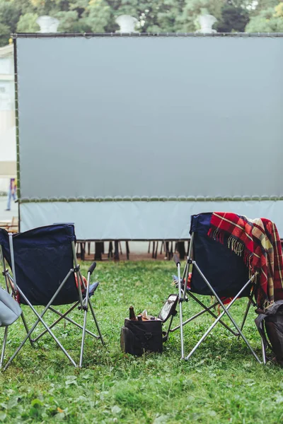 open air cinema concept folding chairs in front of big white screen