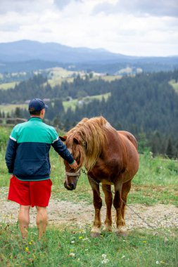 arka planda alan dağlarda at yakınında adam