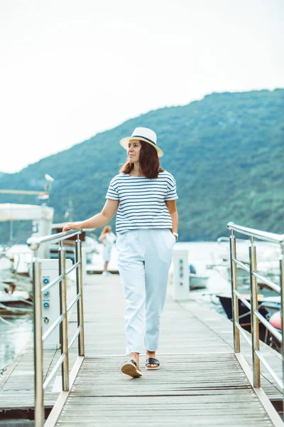 Donna in bianco moda vista di lusso a piedi da barche dock sullo sfondo — Foto Stock