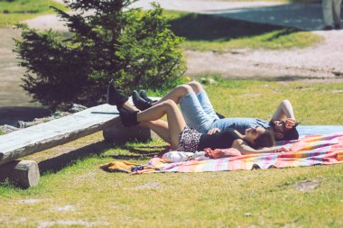 Braies, Italya-13 Haziran 2019: şehir parkında battaniye içinde çift döşeme