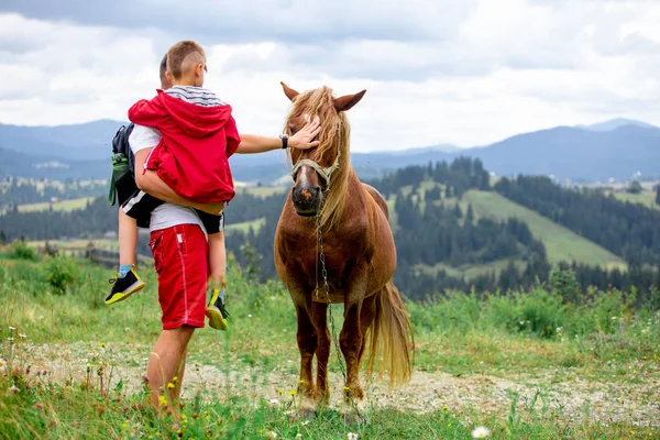 Homme avec enfant animal de compagnie les montagnes de cheval sur fond — Photo