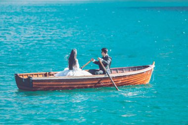 Braies, Italya-13 Haziran 2019: göldeki teknede genç aile damat ve gelin