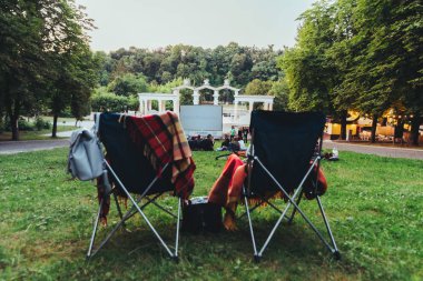 açık hava sinemasında bira ve aperatifler ile soğutma çantası ile iki katlanır sandalyeler
