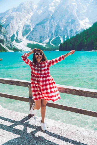 Mulher de pé em frente ao lago nas montanhas — Fotografia de Stock