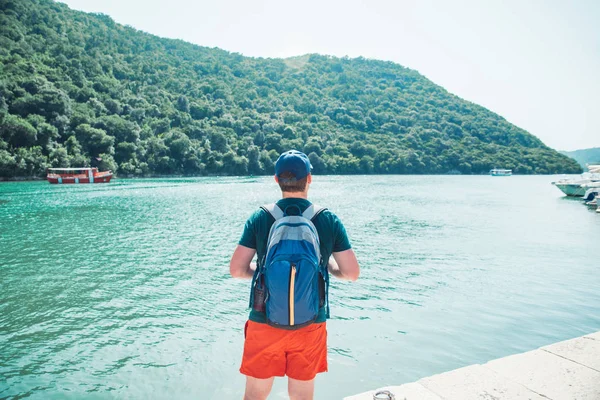 Sırt çantalı bir adam arkadan Sea Bay manzarasına bakıyor. seyahat kavramı — Stok fotoğraf