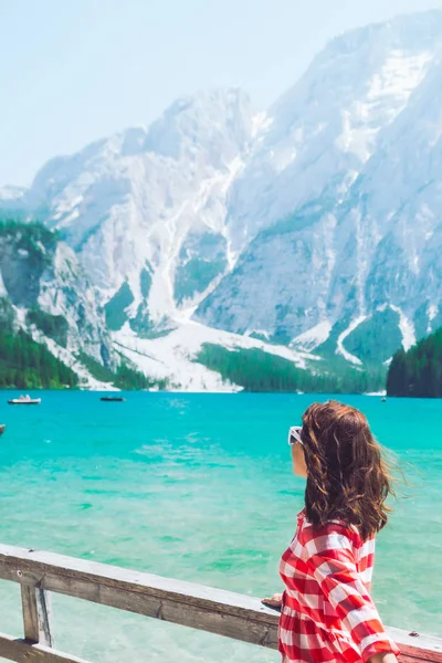 Mujer de pie frente al lago en las montañas — Foto de Stock