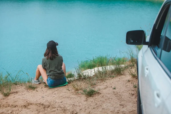 Žena sedící na kraji, který se těší pohledu na jezero — Stock fotografie