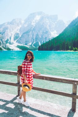 dağlarda gölün önünde duran kadın