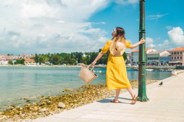 sarı sundress yaz günü deniz rıhtım tarafından yürüyen kadın