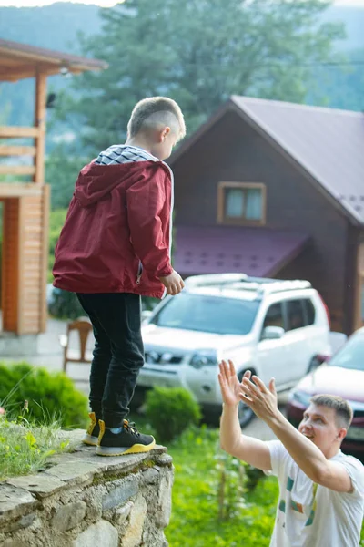 Дитина стрибає батько ловить розваги разом — стокове фото