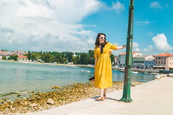 Mujer caminando por muelle de mar en el día de verano en vestido amarillo — Foto de Stock