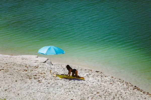Nő a fürdőruha séta homok strand kék napernyő és sárga takaró — Stock Fotó