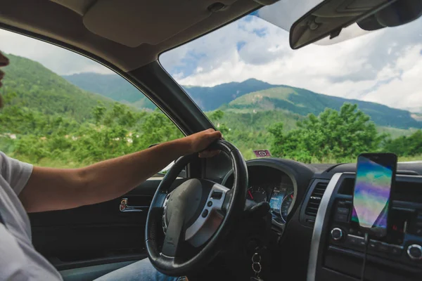 Mann fährt Auto und blickt auf Berge — Stockfoto