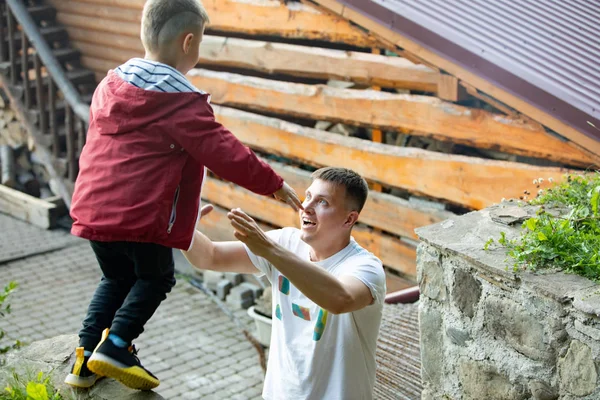 Miúdo saltando pai pegar se divertindo juntos — Fotografia de Stock