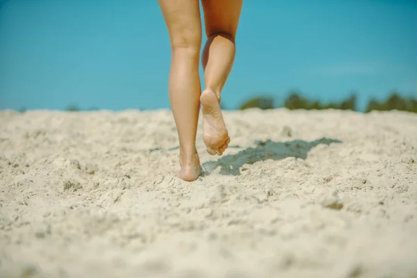 Piernas de mujer caminando por playa de arena hora de verano — Foto de Stock