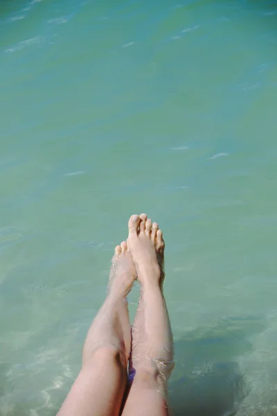 Вид женских ног синяя морская вода на фоне — стоковое фото