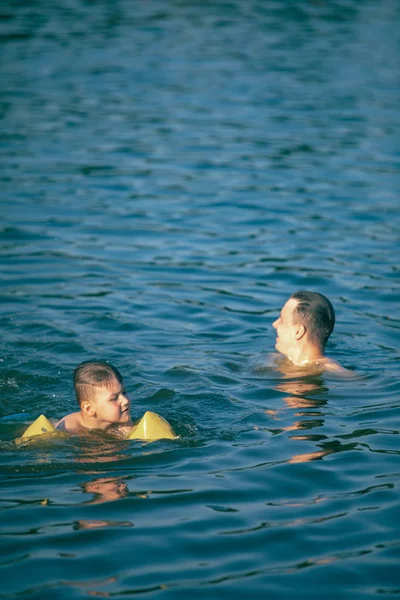 Apa gyerek szórakozik a vízben úszás együtt — Stock Fotó