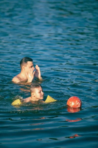 Father with kid having fun in water swimming together — Stock Photo, Image