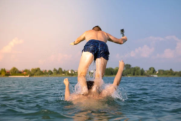 Pár férfi barátok szórakozás a tóban vesz selfie a cselekvés kamera — Stock Fotó