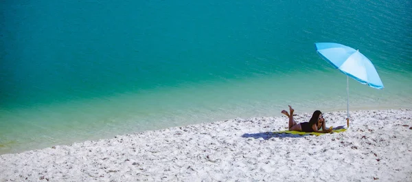 Nő a fürdőruha séta homok strand kék napernyő és sárga takaró — Stock Fotó