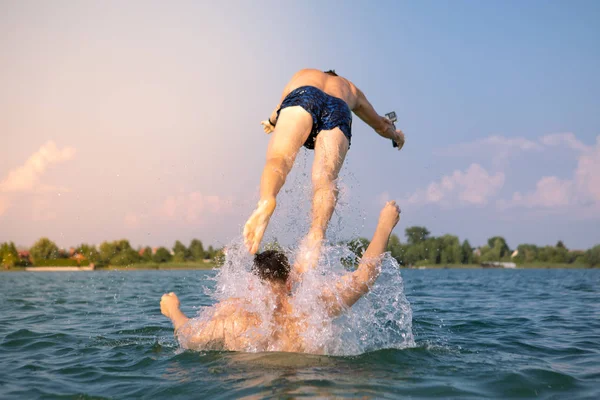 Pár férfi barátok szórakozás a tóban vesz selfie a cselekvés kamera — Stock Fotó
