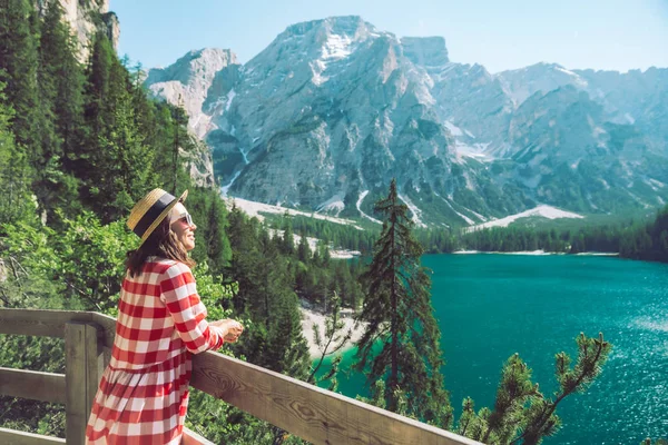 Mulher de pé em frente ao lago nas montanhas — Fotografia de Stock
