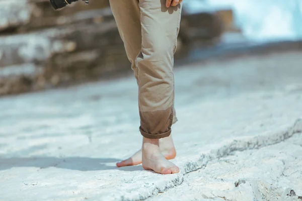 Βρεγμένα πόδια με παντελόνι περπατώντας δίπλα στη θάλασσα βραχώδη παραλία απολαμβάνοντας το νερό — Φωτογραφία Αρχείου