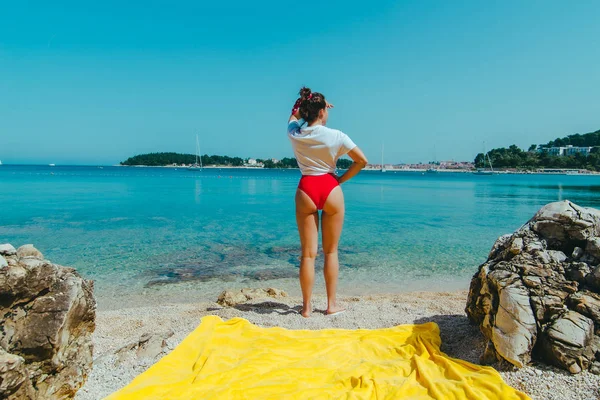 Jonge mooie vrouw met sexy kont op zee strand kijkt uit — Stockfoto