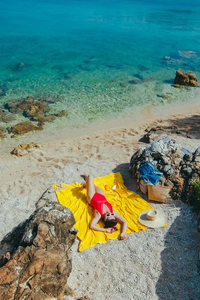 Frau sonnt sich bei sonnigem Tag am Strand — Stockfoto