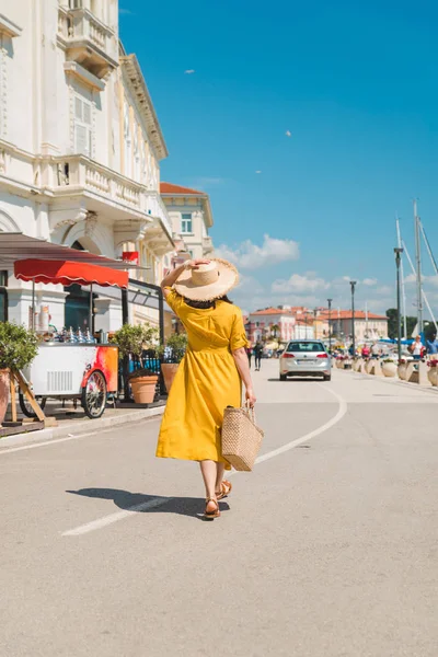 Женщина в желтом платье прогулка по курортному летнему городу — стоковое фото